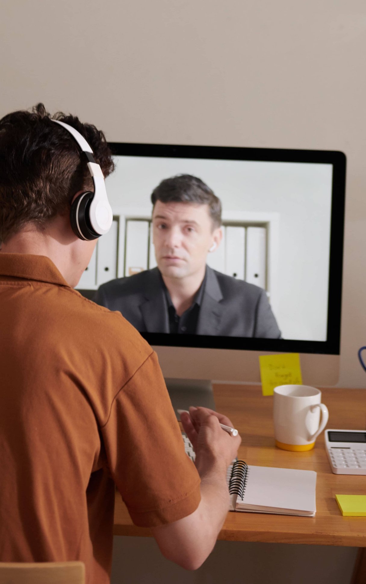 Man with headphones participating in virtual meeting at home office