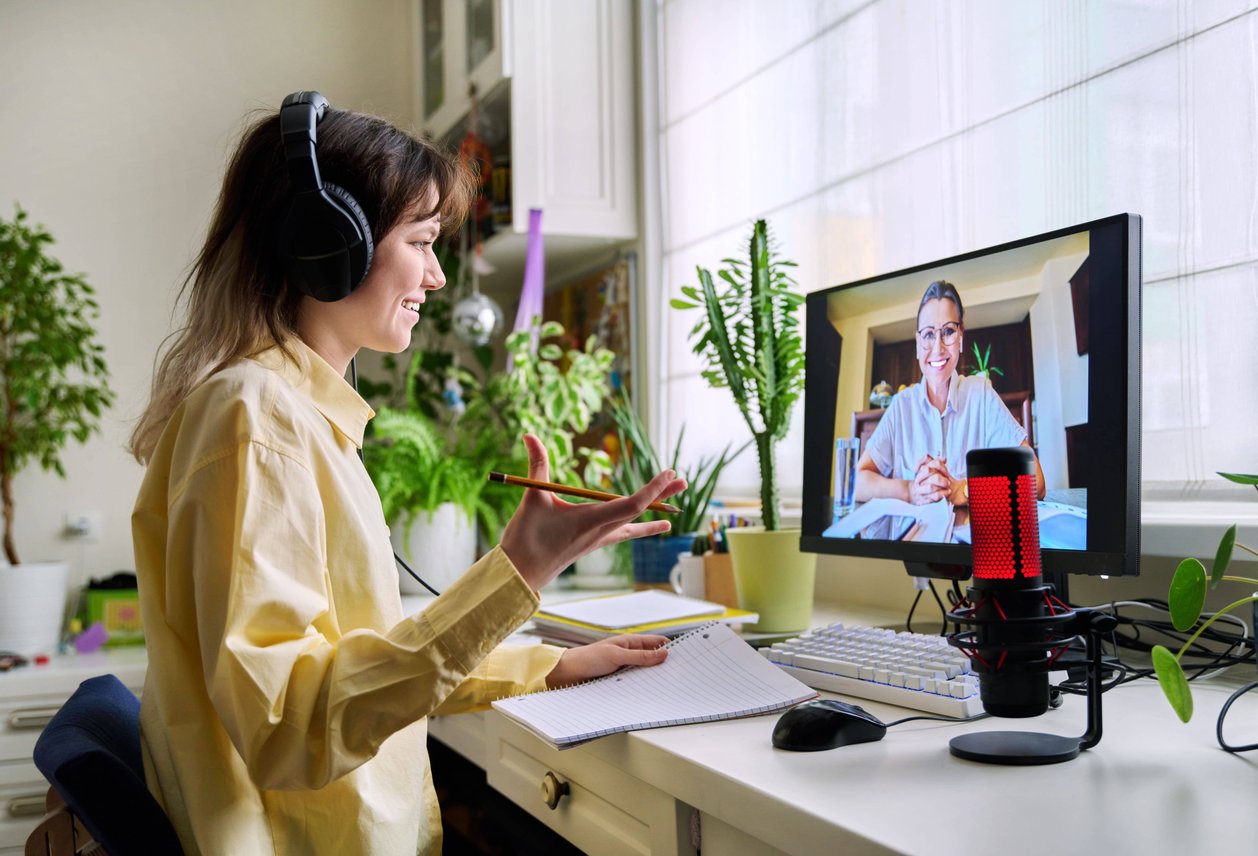 Woman in yellow shirt having animated video conversation on desktop